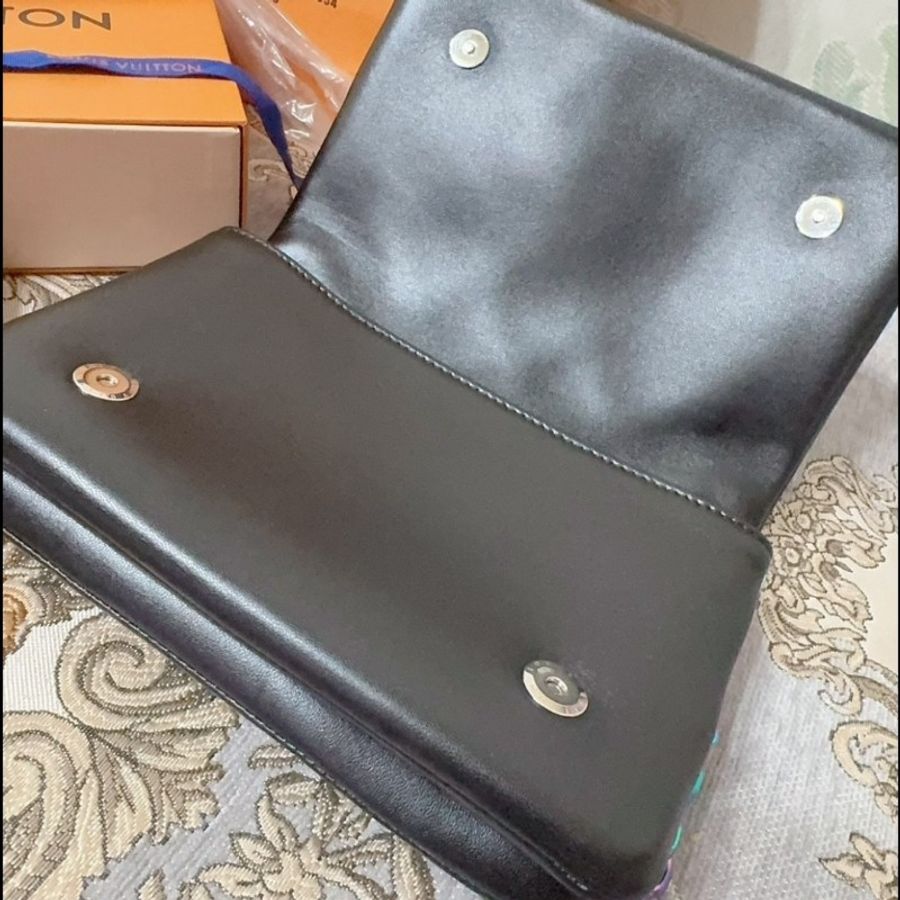 這款包包是路易威登(Louis Vuitton)Twist MM 系列,具有標誌性的LV旋轉鎖扣和Monogram圖案。從設計特徵和炫彩金屬鏈條來看,這款包可能是Twist MM Rainbow Hardware特別版,該系列以特殊的虹彩金屬鏈條和經典黑色Epi皮革聞名,並保留了品牌經典的奢華感與現代設計元素。-6