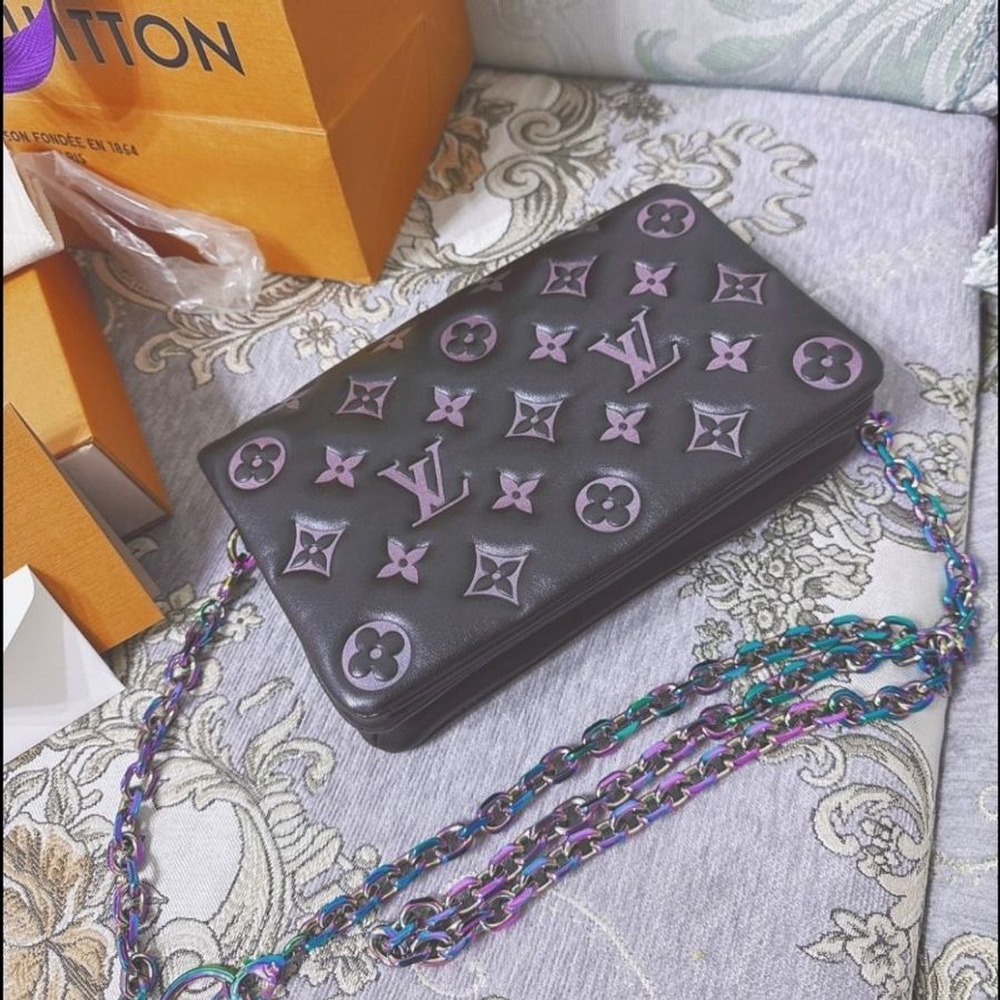 這款包包是路易威登(Louis Vuitton)Twist MM 系列,具有標誌性的LV旋轉鎖扣和Monogram圖案。從設計特徵和炫彩金屬鏈條來看,這款包可能是Twist MM Rainbow Hardware特別版,該系列以特殊的虹彩金屬鏈條和經典黑色Epi皮革聞名,並保留了品牌經典的奢華感與現代設計元素。-9