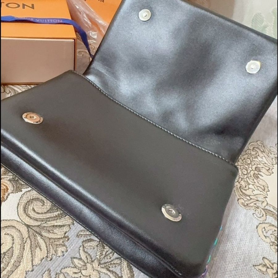 這款包包是路易威登(Louis Vuitton)Twist MM 系列,具有標誌性的LV旋轉鎖扣和Monogram圖案。從設計特徵和炫彩金屬鏈條來看,這款包可能是Twist MM Rainbow Hardware特別版,該系列以特殊的虹彩金屬鏈條和經典黑色Epi皮革聞名,並保留了品牌經典的奢華感與現代設計元素。-11