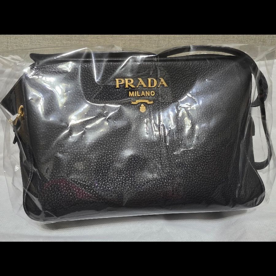 這是一件 Prada Vitello Phenix 黑色荔枝紋牛皮金色金屬標誌相機包。-0