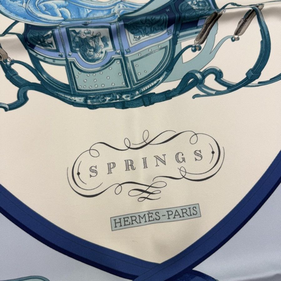 這是愛馬仕(Hermès)的 "Springs" 系列絲巾,由 Philippe Ledoux 設計,以淺藍色和奶油色調為特色。-5