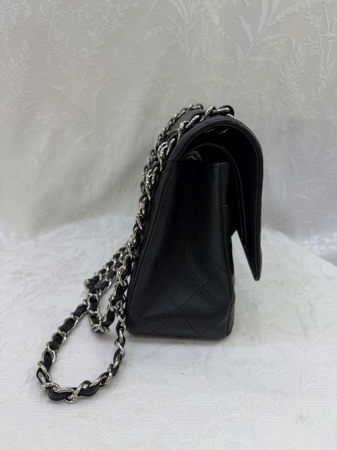 這是一只經典的黑色 CHANEL Classic Flap Jumbo 包款，採用耐用的魚子醬牛皮製成，並搭配銀色金屬鏈帶。-2