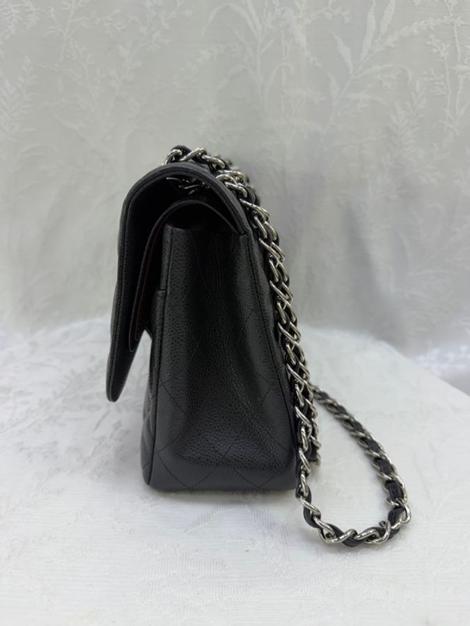 這是一只經典的黑色 CHANEL Classic Flap Jumbo 包款，採用耐用的魚子醬牛皮製成，並搭配銀色金屬鏈帶。-3