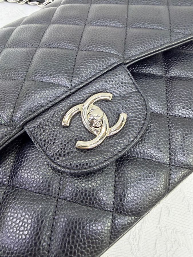 這是一只經典的黑色 CHANEL Classic Flap Jumbo 包款，採用耐用的魚子醬牛皮製成，並搭配銀色金屬鏈帶。-5