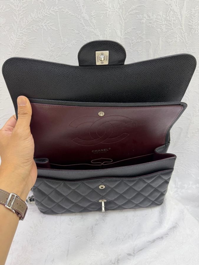 這是一只經典的黑色 CHANEL Classic Flap Jumbo 包款，採用耐用的魚子醬牛皮製成，並搭配銀色金屬鏈帶。-7