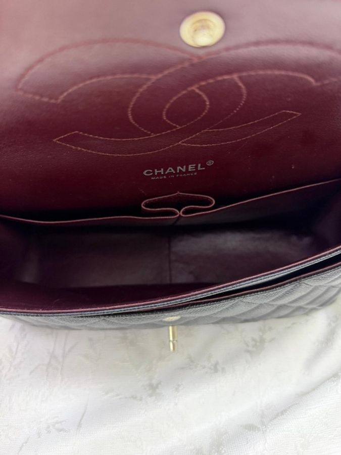 這是一只經典的黑色 CHANEL Classic Flap Jumbo 包款，採用耐用的魚子醬牛皮製成，並搭配銀色金屬鏈帶。-8