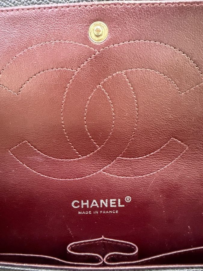 這是一只經典的黑色 CHANEL Classic Flap Jumbo 包款，採用耐用的魚子醬牛皮製成，並搭配銀色金屬鏈帶。-9